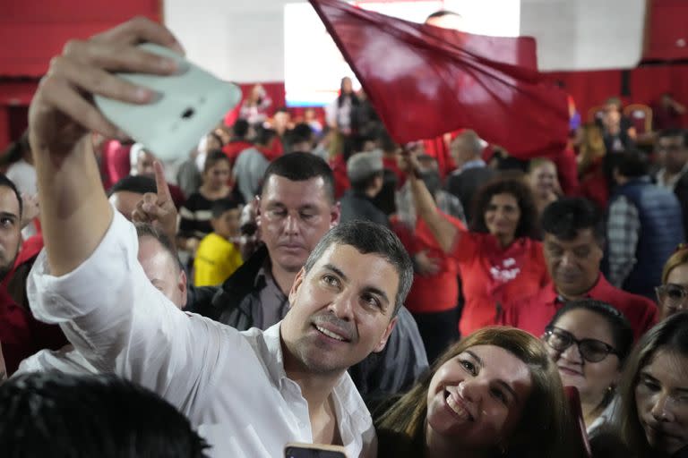 El candidato oficialista, Santiago Peña, se toma una selfie con una simpatizante