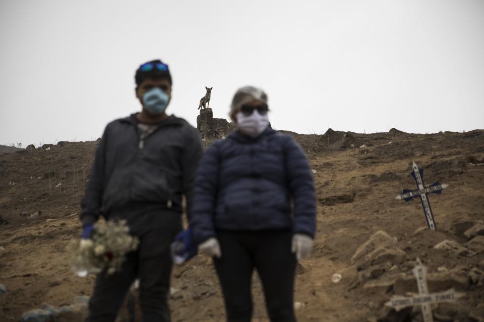 Adrian Tarazona and her mother Rosa watch the burial of Adrian Tarazona Manrique, 72, who died of COVID-19 complications, at the Nueva Esperanza cemetery on outskirts from Lima, Peru, Thursday, May 28, 2020. (AP Photo/Rodrigo Abd)