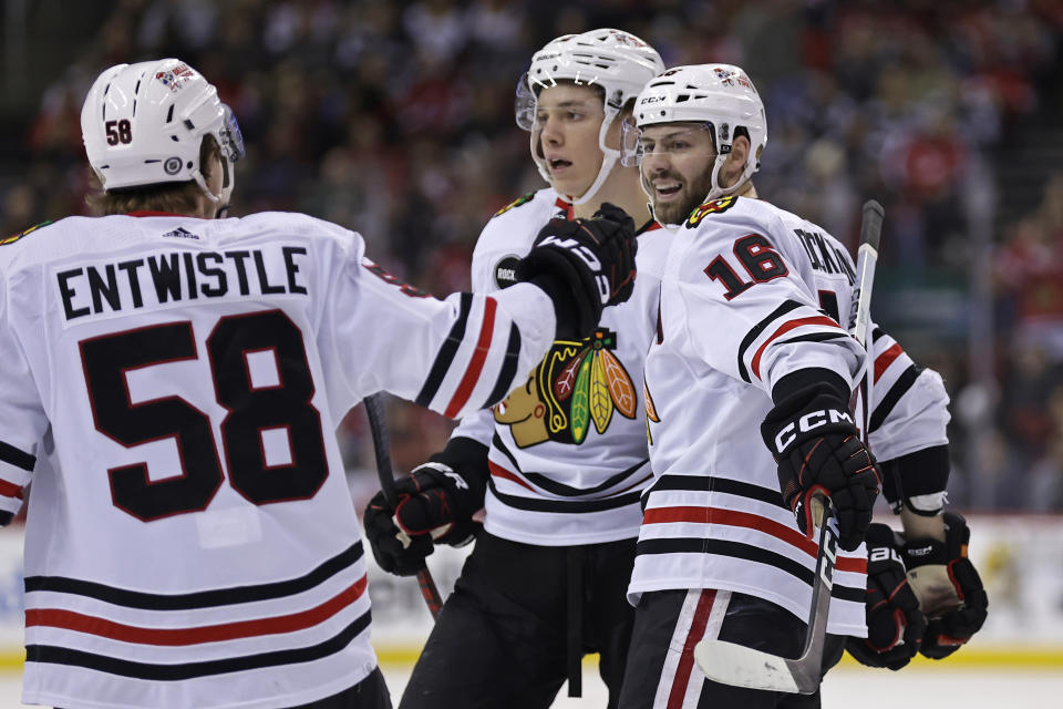 Chicago Blackhawks center Jason Dickinson (16) is congratulated by MacKenzie Entwistle (58) after scoring a goal against the New Jersey Devils during the first period of an NHL hockey game Friday, Jan. 5, 2024, in Newark, N.J. (AP Photo/Adam Hunger)