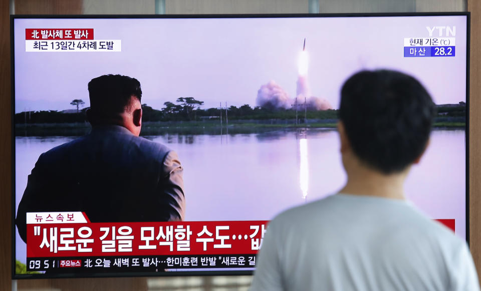 A man watches a TV showing a file image of a North Korea's missile launch during a news program at the Seoul Railway Station in Seoul, South Korea, Tuesday, Aug. 6, 2019. North Korea on Tuesday continued to ramp up its weapons demonstrations by firing unidentified projectiles twice into the sea while lashing out at the United States and South Korea for continuing their joint military exercises that the North says could derail fragile nuclear diplomacy. The sign reads "North Korea could seek a new road." (AP Photo/Ahn Young-joon)