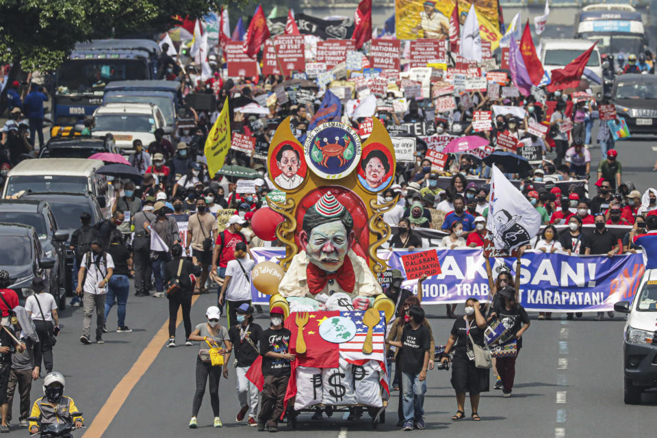 Thousands of protesters march along Commonwealth Avenue towards the House of Representatives Congress in Quezon City, Philippines ahead of the State of the Nation address Monday, July 25, 2022. Philippine President Ferdinand Marcos Jr. will deliver his first State of the Nation address Monday with momentum from his landslide election victory, but he's hamstrung by history as an ousted dictator’s son and daunting economic headwinds. (AP Photo/Gerard Carreon)