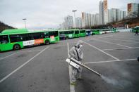 An employee from a disinfection service company sanitizes the floor of a bus garage in Seoul