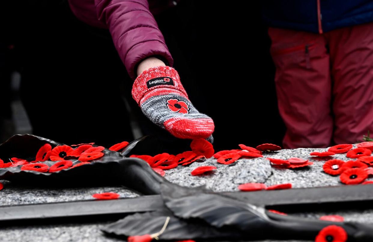 A person lays a poppy on the Tomb of the Unknown Soldier, after the National Remembrance Day Ceremony at the National War Memorial in Ottawa, on Saturday, Nov. 11, 2023. (Justin Tang/The Canadian Press - image credit)