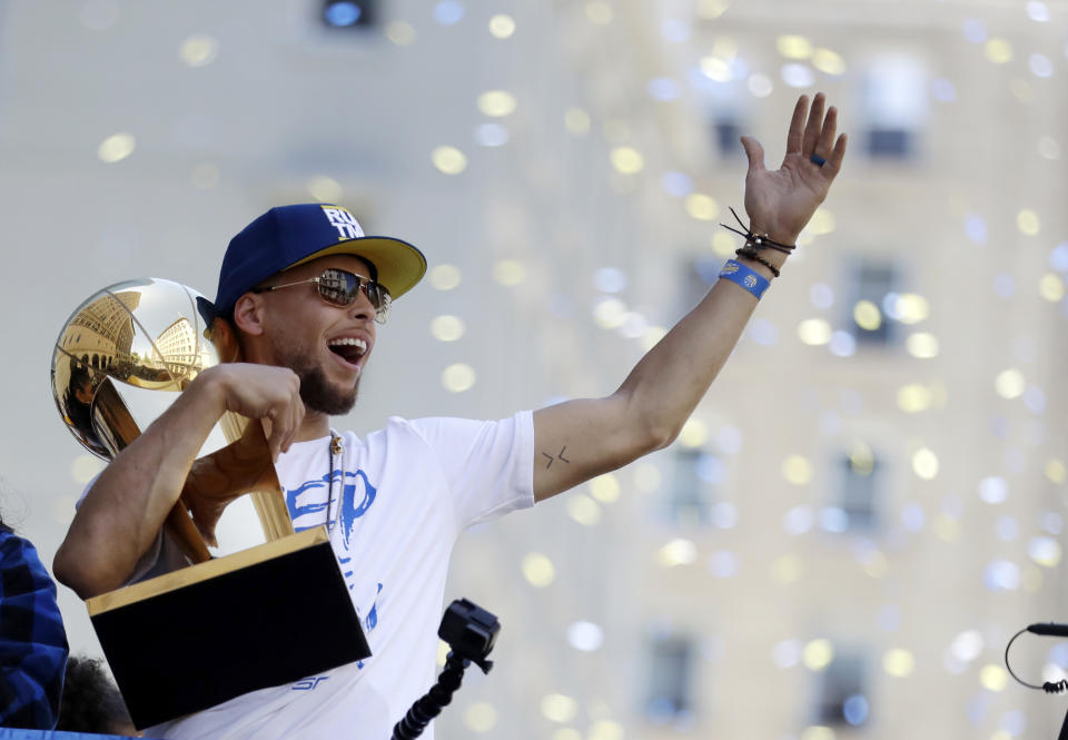 FILE - In this June 12, 2018, file photo, Golden State Warriors' Stephen Curry carries the Larry O'Brien trophy during the team's NBA championship parade in Oakland, Calif. A fifth straight trip to the NBA Finals would be an incredible feat.(AP Photo/Marcio Jose Sanchez, file)