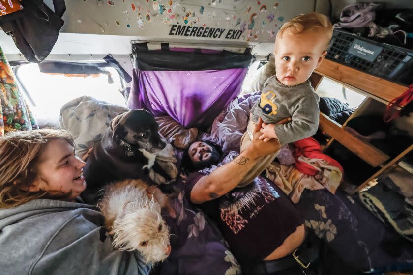 Isa Stephen holds Elijah, 10 months, with partner Mollie Ginsen, at left, and another son.