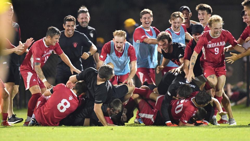 The Indiana men's soccer team celebrates Friday night's 3-2 overtime victory at Notre Dame with a dogpile on Ben Yeagley (20) as IU head coach Todd Yeagley, left, tumbles over the top. Ben Yeagley, bottom right, scored the game-winner, his first career goal as a Hoosier.