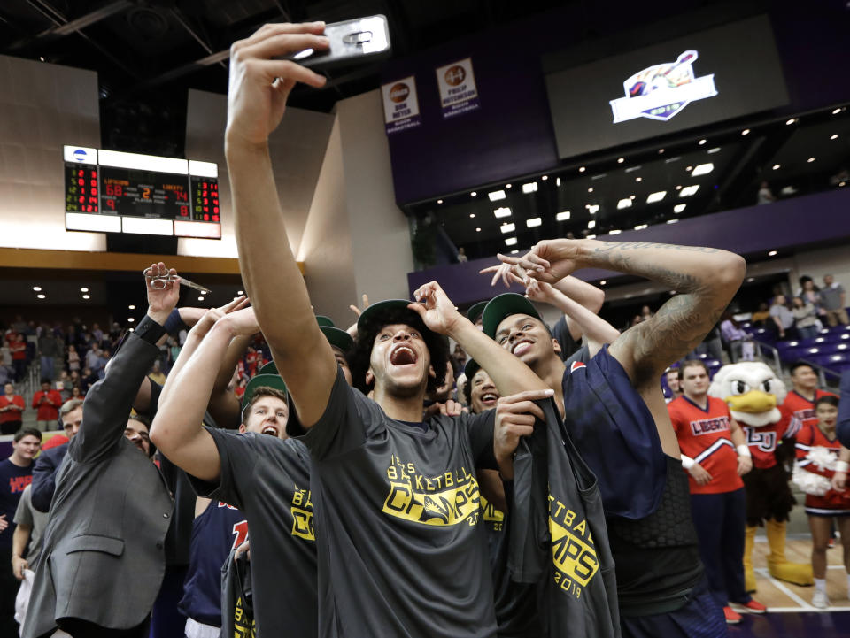 Liberty players celebrate after beating Lipscomb in the Atlantic Sun NCAA college basketball tournament championship game Sunday, March 10, 2019, in Nashville, Tenn. Liberty won 74-68. (AP Photo/Mark Humphrey)