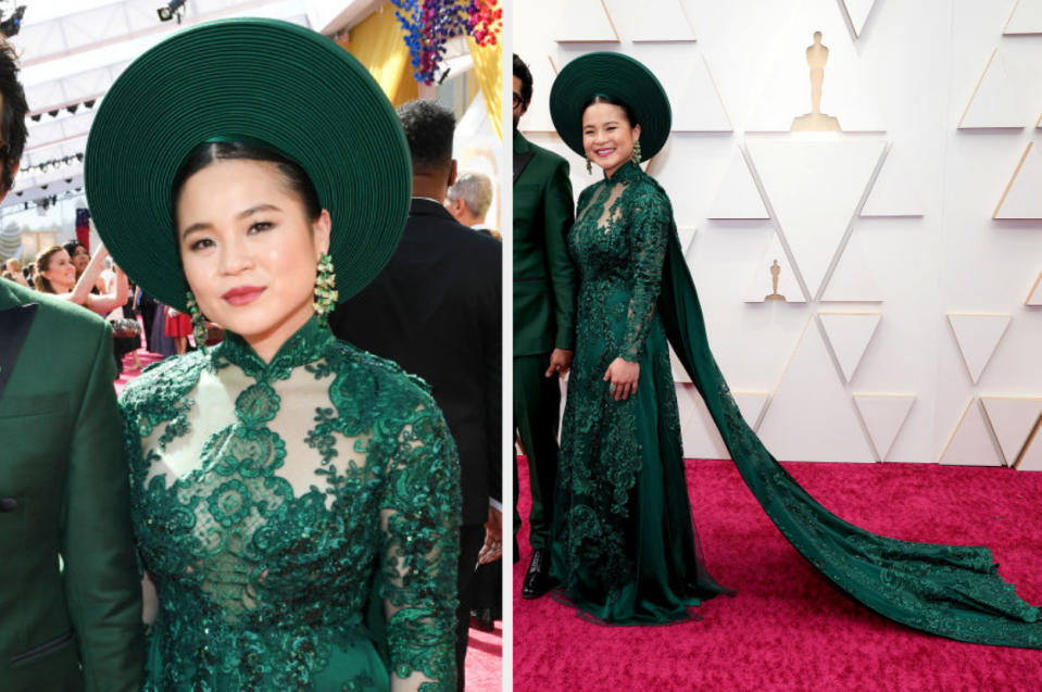 Woman in elaborate green gown with matching hat on red carpet