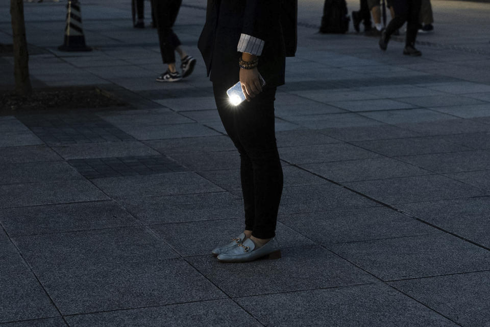 People hold smartphone with flash light near Victoria Park, the city's venue for the annual 1989 Tiananmen massacre vigil, on the 35th anniversary of China's Tiananmen Square crackdown in Hong Kong, Tuesday, June 4, 2024. (AP Photo/Chan Long Hei)