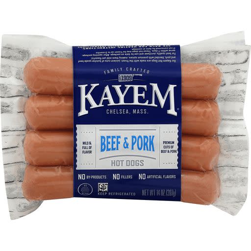 Package of Kayem Beef & Pork Hot Dogs featuring six hot dogs, labeled "No By-Products," "No Fillers," and "No Artificial Flavors," with instructions to keep refrigerated