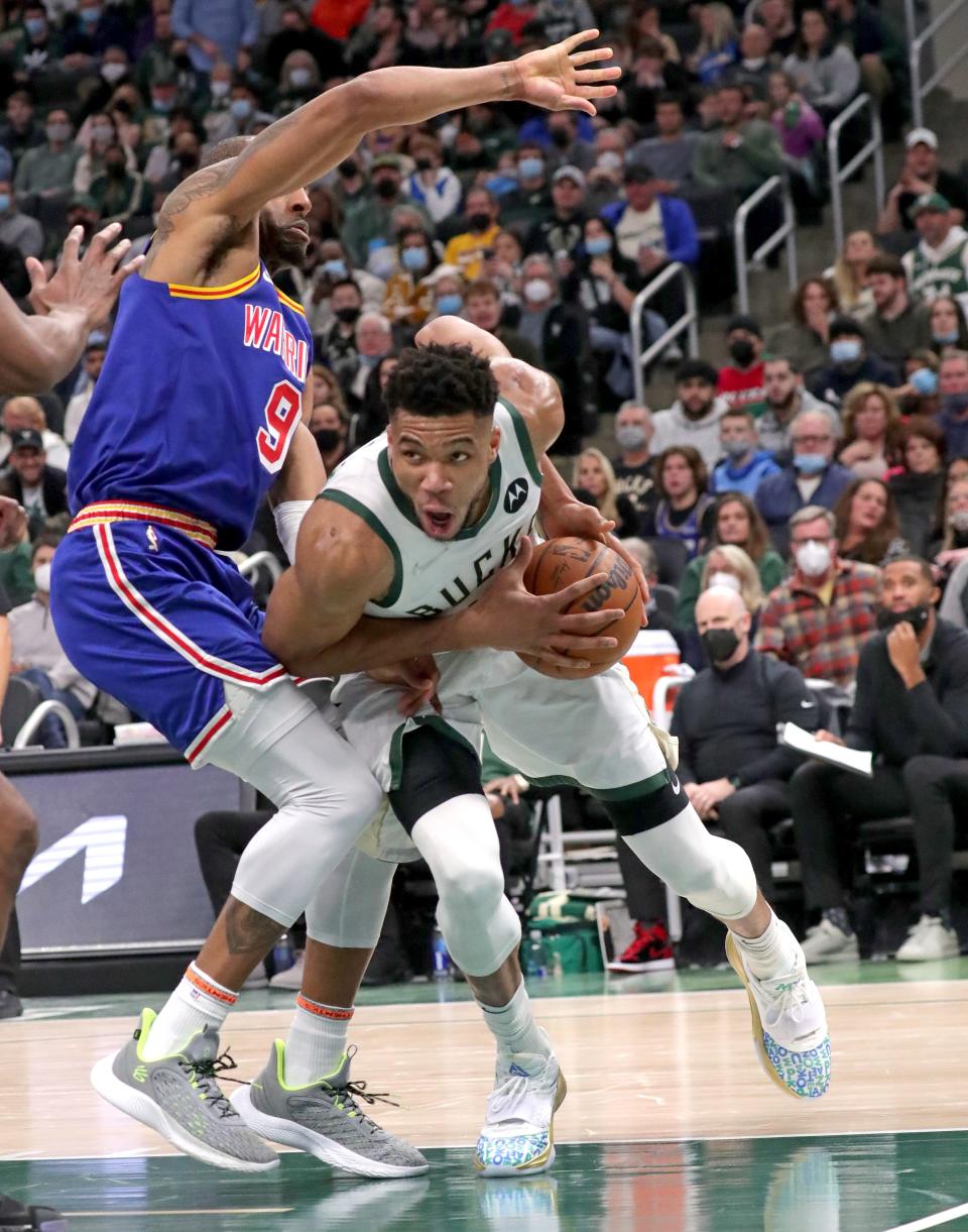 Bucks forward Giannis Antetokounmpo drives past Warriors forward Andre Iguodala on Thursday night at Fiserv Forum.