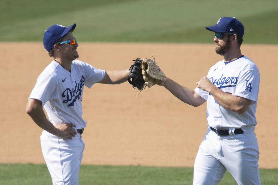 Los Angeles Dodgers first baseman Enrique Hernandez, left, and right fielder Adam Kolarek celebrate their win over the Los Angeles Angels in a baseball game in Los Angeles, Sunday, Sept. 27, 2020. (AP Photo/Kyusung Gong)