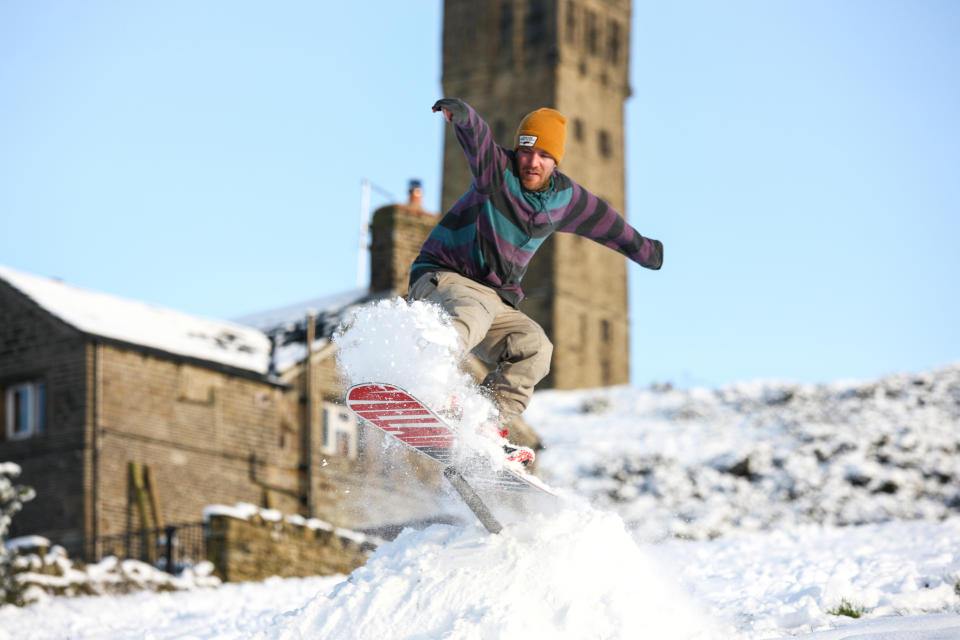 HUDDERSFIELD, UNITED KINGDOM - 2021/01/15: A man seen snowboarding on  a hill in Huddersfield. Many parts of West Yorkshire are still covered with snow following heavy snowfall the previous day, which caused widespread disruption to travel. (Photo by Adam Vaughan/SOPA Images/LightRocket via Getty Images)