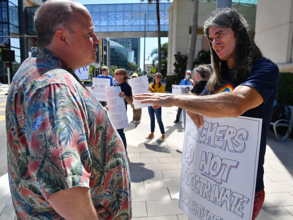 David Happe, left, a self-described community agitator and supporter of Moms for Liberty discusses what is and isn't being taught in public schools with Pinellas County history teacher Brandt Robinson. They spoke outside the hotel where the first Moms for Liberty National Summit was being held in July in Tampa. Teachers said the Moms for Liberty group was wrongly accusing them of trying to indoctrinate their students with a woke agenda.