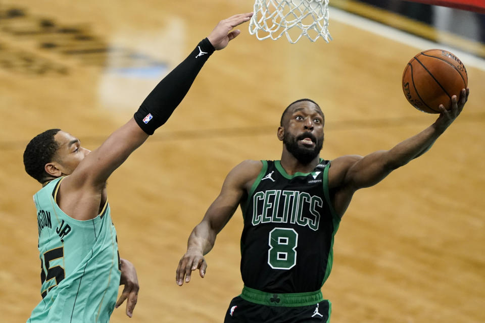 Kemba Walker goes to the hoop with the ball in his left hand as P.J. Washington extends his arm to defend.