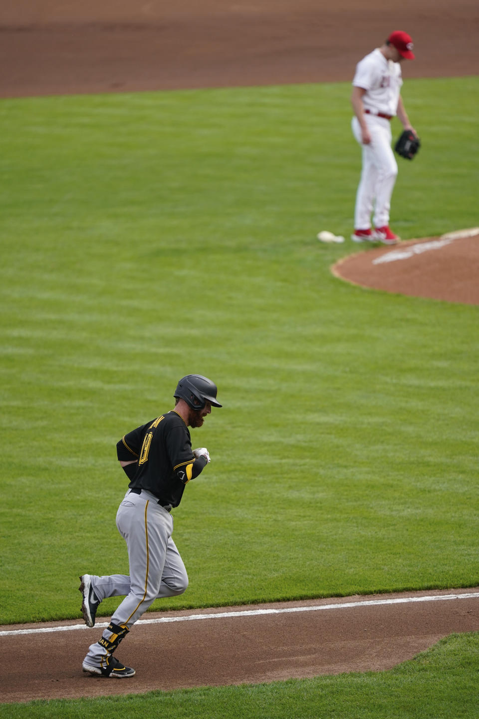 Pittsburgh Pirates' Colin Moran, bottom, runs the bases after hitting a home run in the first inning of a baseball game against the Cincinnati Reds at Great American Ballpark in Cincinnati, Thursday, Aug. 13, 2020. (AP Photo/Bryan Woolston)