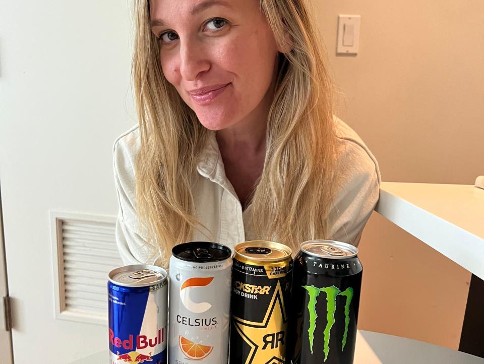 jen posing with four cans of energy drinks