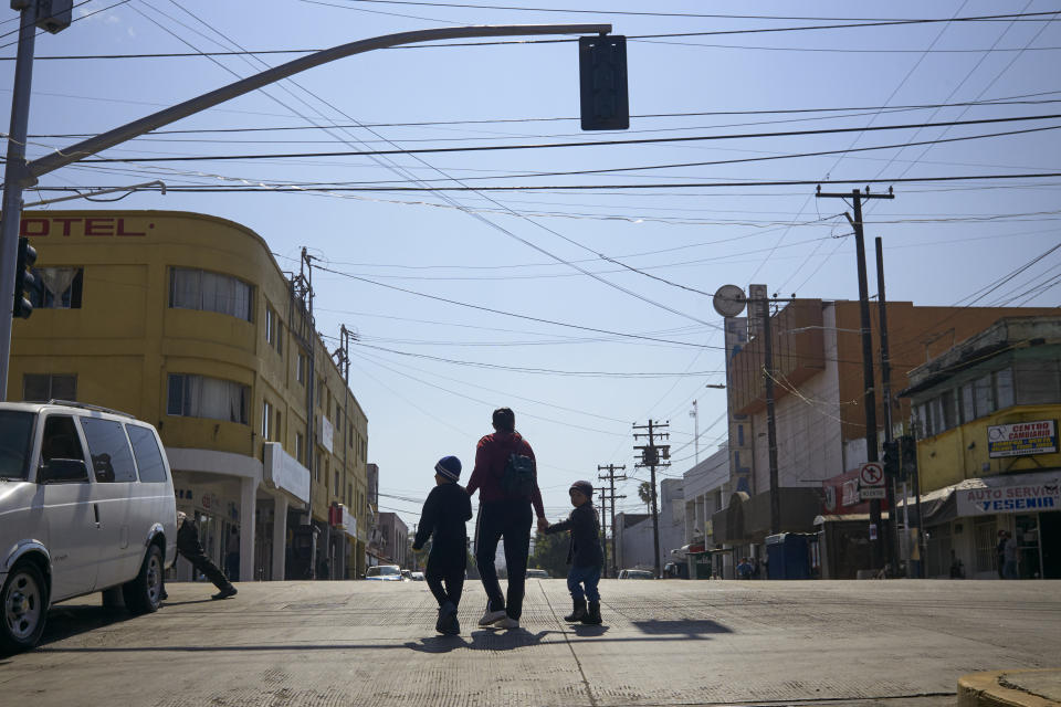 FILE - In this March 5, 2019, file photo, Ruth Aracely Monroy walks with her sons in Tijuana, Mexico. After requesting asylum in the United States, the family was returned to Tijuana to wait for their hearing in San Diego. A U.S. judge on Monday, April 8, 2019, blocked the Trump administration's policy of returning asylum seekers to Mexico as they wait for an immigration court to hear their cases but the order won't immediately go into effect. Judge Richard Seeborg in San Francisco granted a request by civil liberties groups to halt the practice while their lawsuit moves forward. He put the decision on hold until Friday, April 12 to give U.S. officials the chance to appeal. (AP Photo/Gregory Bull, File)