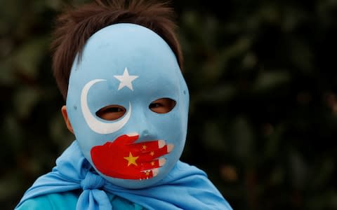 An ethnic Uighur boy living in Turkey, takes part in a protest against China - Credit: REUTERS/Murad Sezer