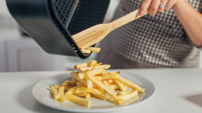 Person removing food from an air fryer