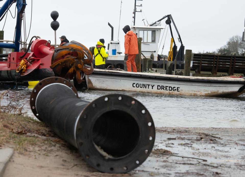 Crews ready the Barnstable County dredge, left, on Thursday along the Town Dock in Cotuit.