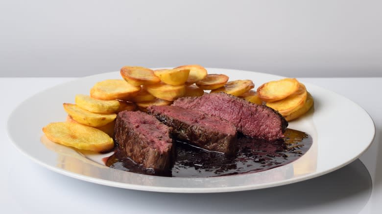 Sliced backstrap on a plate with potatoes