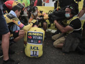 Slovenia's Primoz Roglic is comforted by teammates after losing the overall leader's yellow jersey in stage 20 of the Tour de France cycling race, an individual time trial over 36.2 kilometers (22.5 miles), from Lure to La Planche des Belles Filles, France, Saturday, Sept. 19, 2020. (Christophe Petit-Tesson/Pool via AP)