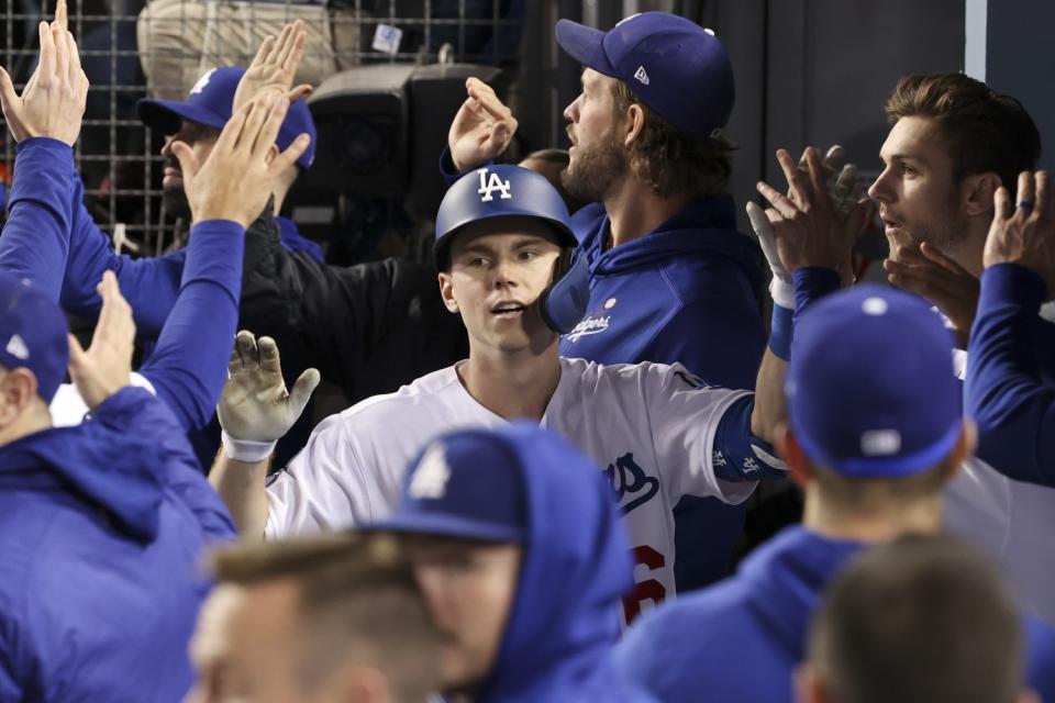 Will Smith celebrates with teammates in the dugout after hitting a two-run home run for the Dodgers in the eighth inning.