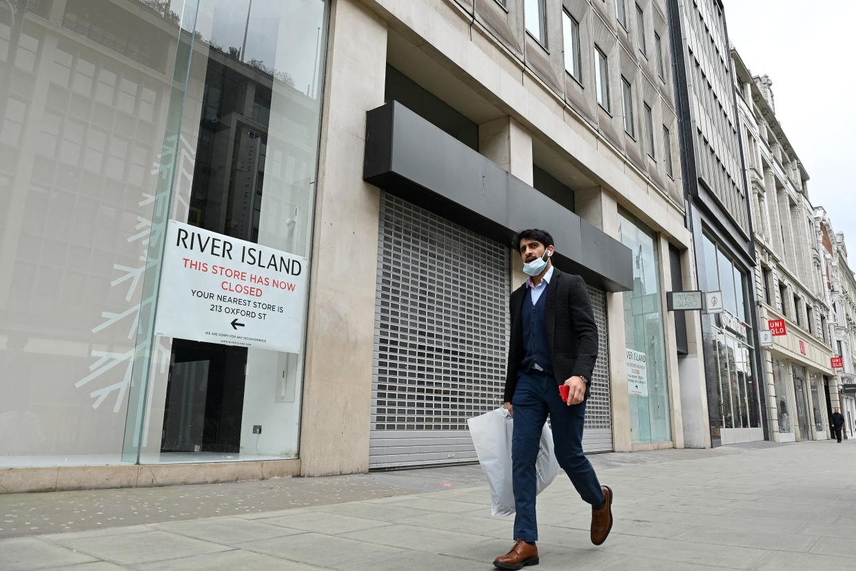 A pedestrian walks past a shuttered and closed-down branch of a River Island clothes store on Oxford Street in central London on March 24, 2021. - Britain's annual inflation rate unexpectedly fell in February as coronavirus curbs sparked heavy discounting for clothing and footwear, official data showed Wednesday, soothing market concerns over inflationary pressures. (Photo by JUSTIN TALLIS / AFP) (Photo by JUSTIN TALLIS/AFP via Getty Images)
