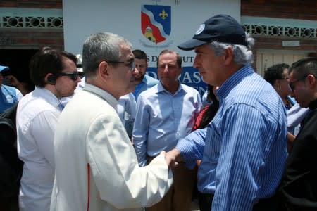 Colombian Minister of Health Juan Pablo Uribe shakes hands with Bishop of the Diocese of Cucuta, Victor Manuel Ochoa, during a visit at the "Divina Providencia" migrant shelter in Cucuta