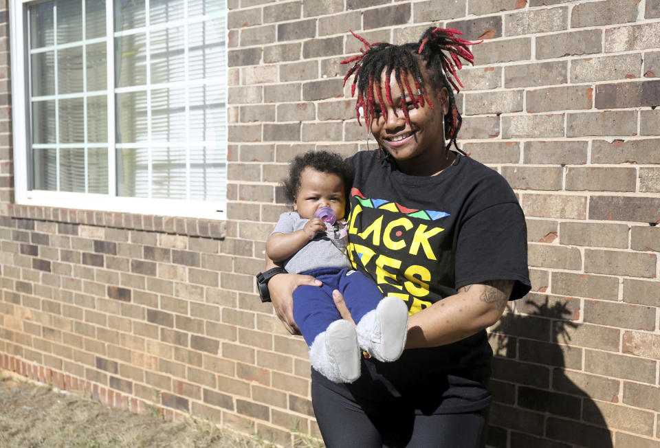 Nia Thomas holds her 4-month-old daughter, Nilah, in front of their Atlanta home on Wednesday, Feb. 14, 2024. Thomas was bailed out of jail by the nonprofit Barred Business in 2022 through the “Mama’s Day Bail Out,” initiative, a practice that could be significantly restricted, if not criminalized, under a recently passed Georgia bill. (AP Photo/R.J. Rico)