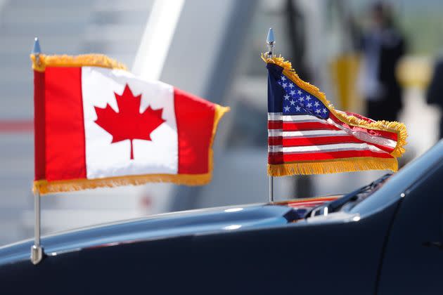 A limousine drives with U.S. and Canadian flags before the arrival of U.S. President Donald Trump at Canadian Forces Base Bagotville in Bagotville, Que. on June 8, 2018 for G7 summit. 