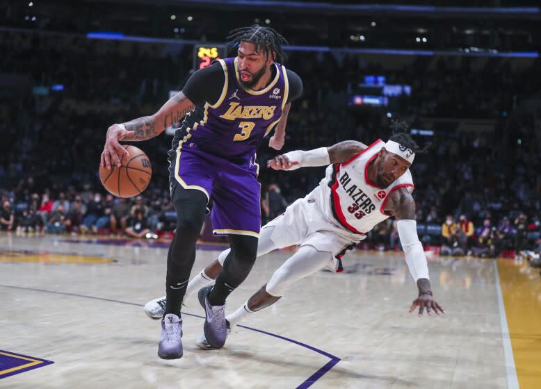 Los Angeles, CA - February 02: Los Angeles Lakers center Anthony Davis, left, battles for control of the ball against Portland Trail Blazers forward Robert Covington as he falls to the ground in the second half at Crypto.com Arena in Los Angeles Wednesday, Feb. 2, 2022. Lakers won 94-99. (Allen J. Schaben / Los Angeles Times)