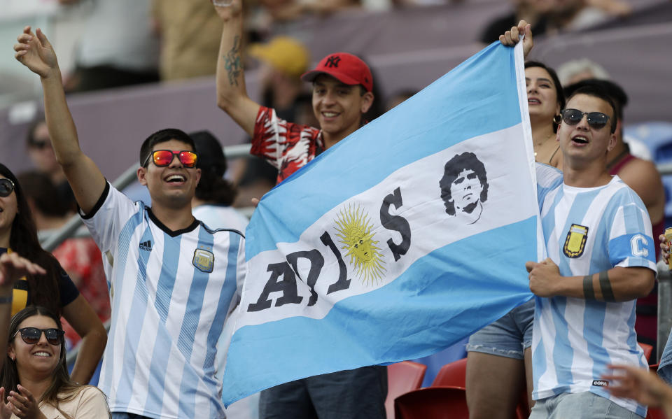 Argentina fans hold a flag in memory of soccer star Diego Maradona ahead of the Tri-Nations rugby test between Argentina and the All Blacks in Newcastle, Australia, Saturday, Nov. 28, 2020. (AP Photo/Rick Rycroft)