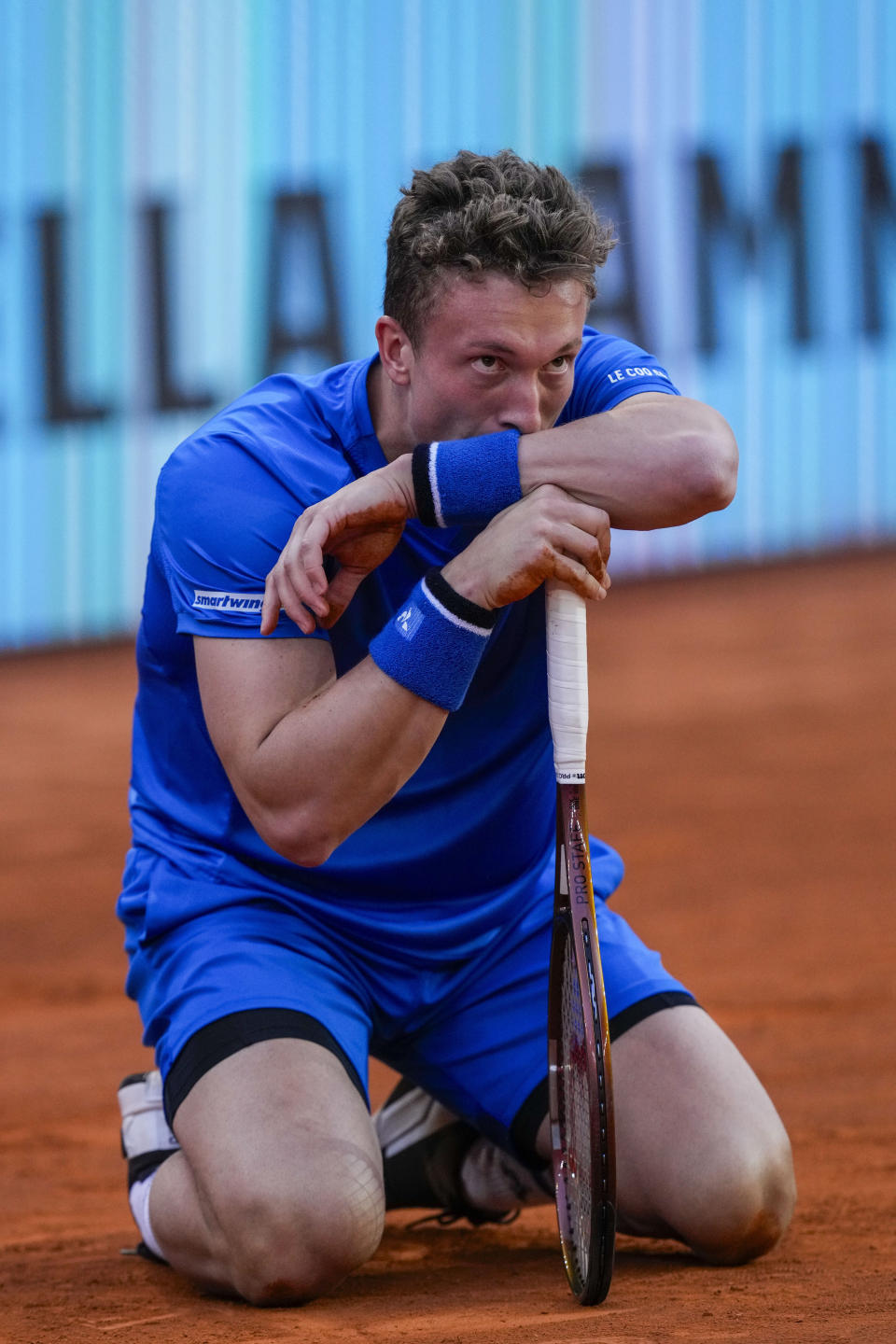 Jiri Lehecka, of the Czech Republic, lies on the ground before retiring during a semi-final match against Felix Auger-Aliassime, of Canada, at the Mutua Madrid Open tennis tournament in Madrid, Spain, Friday, May 3, 2024. (AP Photo/Bernat Armangue)