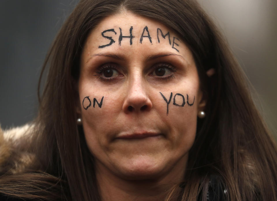 A demonstrator gathers outside New Scotland Yard in London, Sunday, March 14, 2021 during a protest over the abduction and murder of Sarah Everard and the subsequent handling by the police of a vigil honoring the victim. London's Metropolitan Police force was under heavy pressure Sunday to explain its actions during a vigil for Sarah Everard whom one of the force's own officers is accused of murdering. (AP Photo/Frank Augstein)