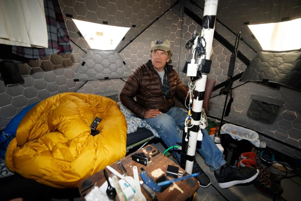 Gary Peters takes a break in his tent at the east safe outdoor space in the parking lot of the city of Denver Human Service building in Denver (AP)