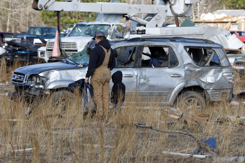 Friends and family help sift through debris looking for personal items after a tornado that ripped through Central Alabama earlier this week along County Road 140 where loss of life occurred Saturday, Jan. 14, 2023, in White City, Ala.. (AP Photo/Butch Dill)