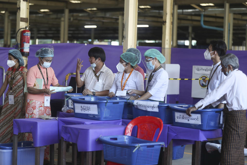 Officials of the Union Election Commission prepare to count ballots at a polling station Sunday, Nov. 8, 2020, in Yangon, Myanmar. Voters in Yangon turned up early Sunday in large numbers to vote in nationwide elections that are expected to return to power the party of Nobel Peace Prize laureate Aung San Suu Kyi. (AP Photo/Thein Zaw)