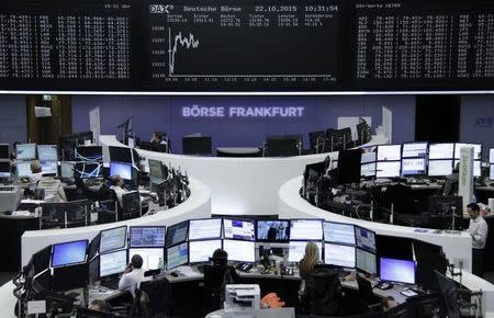 Traders work at their screens in front of the German share price index, DAX board, at the stock exchange in Frankfurt, Germany, October 22, 2015. REUTERS/Staff/remote