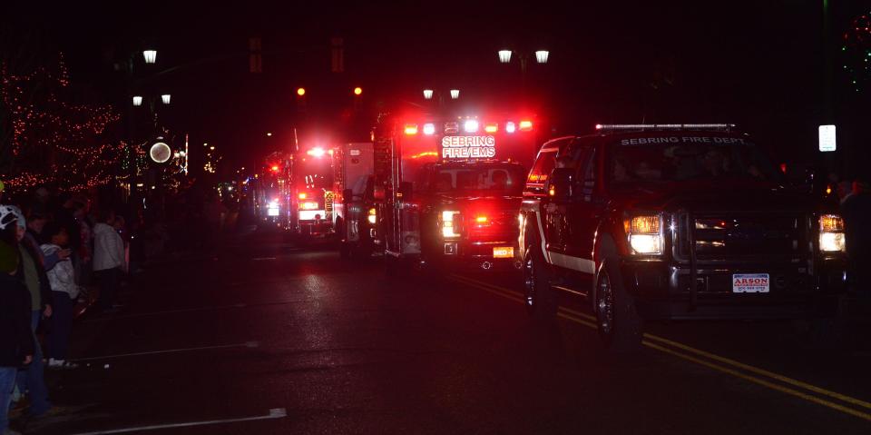 A long line of emergency vehicles blast their sirens and light the night as they make their way down 15th Street in Sebring Village during the annual Christmas parade on Saturday, Dec. 2, 2023.