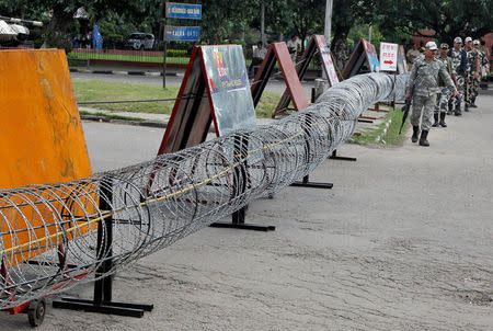 Police patrol next to concertina wire barricade outside a court in Panchkula in Haryana, India, August 24, 2017. REUTERS/Ajay Verma