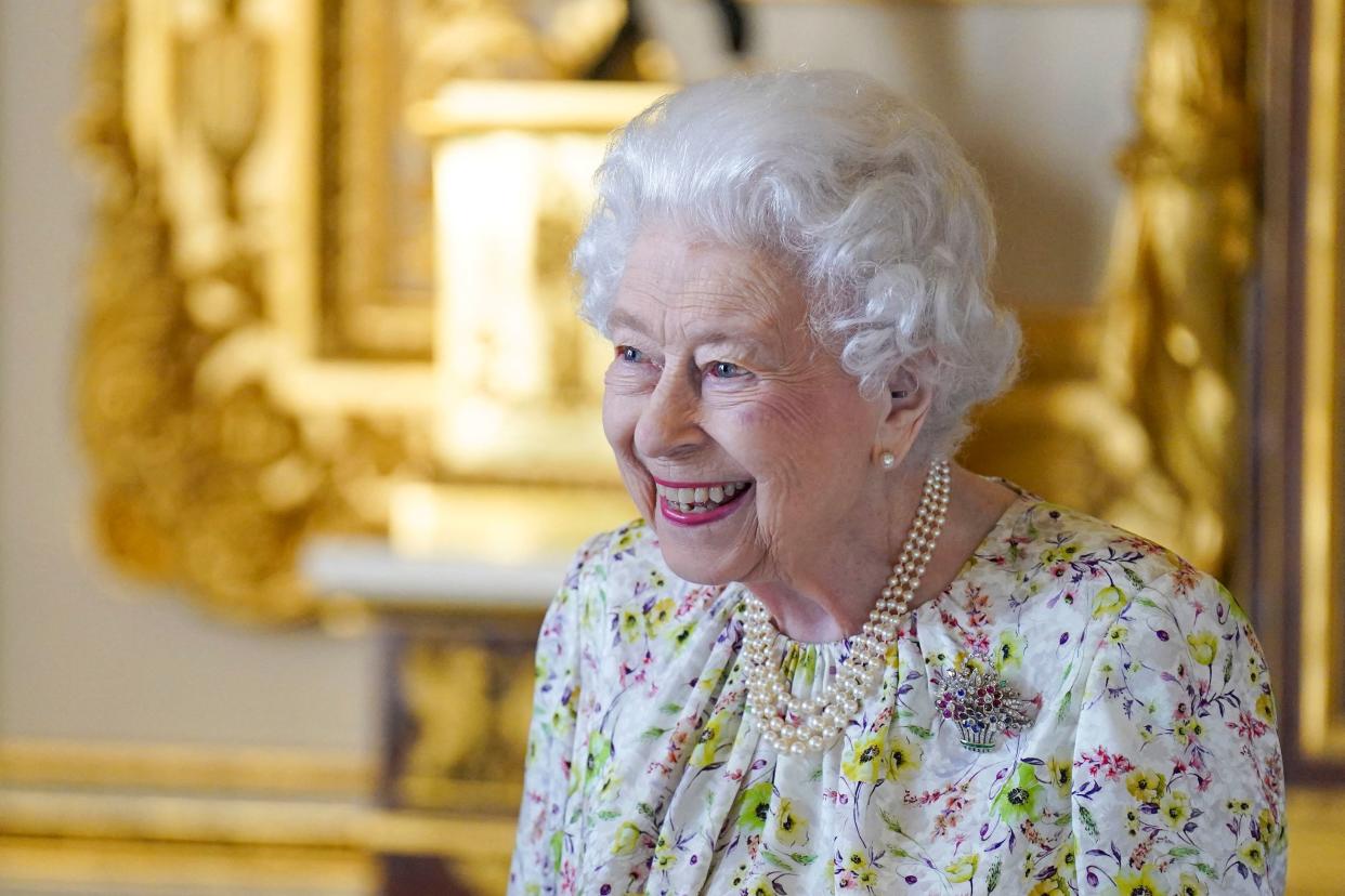 Britain's Queen Elizabeth II smiles as she arrives to view a display of artefacts from Halcyon Days to commemorate the company's 70th anniversary in the White Drawing Room at Windsor Castle on March 23, 2022. - The Queen viewed a selection of hand-decorated archive enamelware and fine bone china from Halcyon Days, including their earliest designs from the 1950s. (Photo by Steve Parsons / POOL / AFP) (Photo by STEVE PARSONS/POOL/AFP via Getty Images)