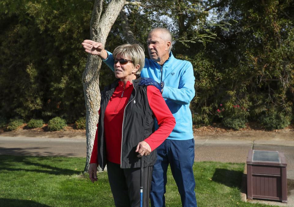 Visually impaired golfer Linda Port is helped lining up her shot by husband Fred as the two practiced at The Vintage Club in Indian Wells, Calif., Dec. 16, 2022.