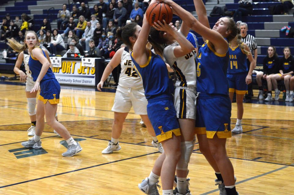 Airport's Jillian Baker looks for room to shoot squeezed between a pair of Ida defenders on Thursday, Dec. 29, 2022 during the Airport Showcase.