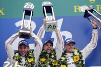 (L-R) Porsche 919 Hybrid number 19 driver Nick Tandy of Britain, Earl Bamber of New Zeland, and Nico Hulkenberg of Germany celebrate on the podium after winning the Le Mans 24-hour sportscar race in Le Mans, central France June 14, 2015. REUTERS/Stephane Mahe