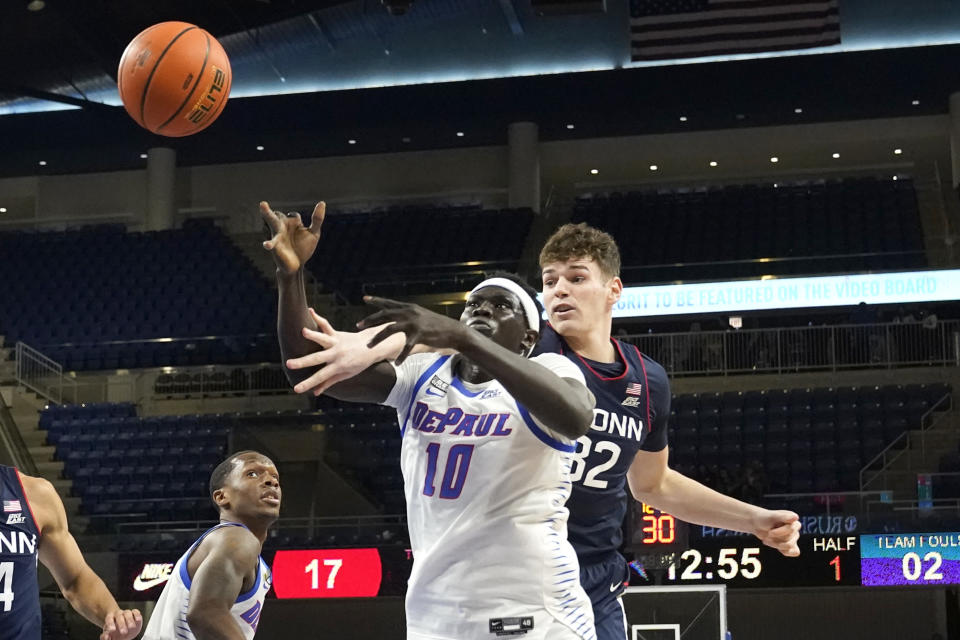 DePaul's Yor Anei and Connecticut's Donovan Clingan battles for a loose ball during the first half of an NCAA college basketball game Tuesday, Jan. 31, 2023, in Chicago. (AP Photo/Charles Rex Arbogast)