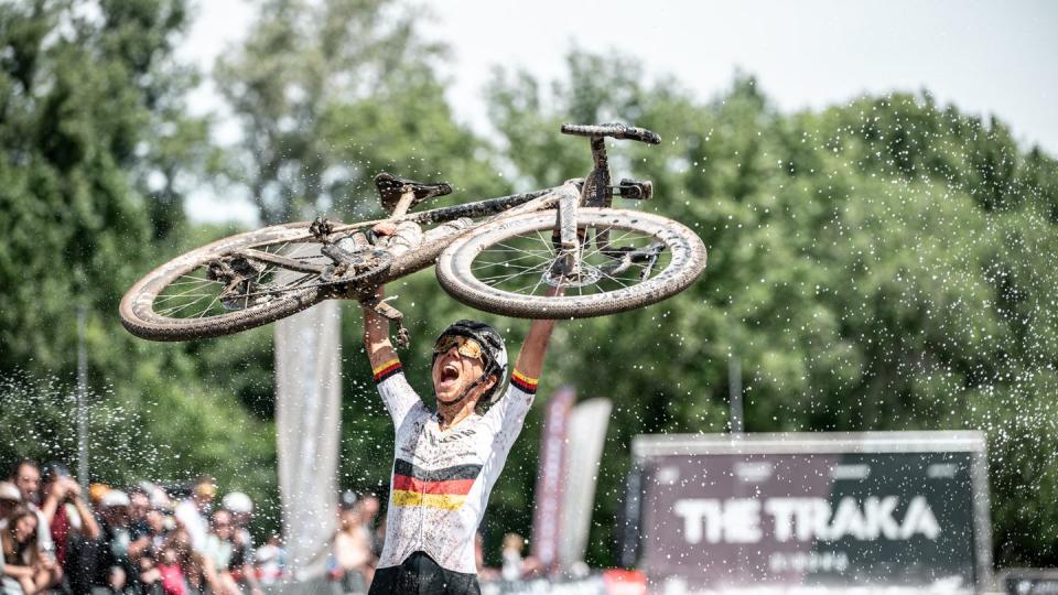 carolin schiff holding up a bicycle after winning the traka 2024