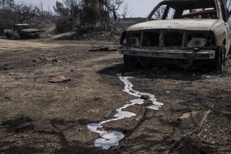 Burnt cars are seen after a wildfire near Gennadi village, on the Aegean Sea island of Rhodes, southeastern Greece, on Thursday, July 27, 2023. The wildfires have raged across parts of the country during three successive Mediterranean heat waves over two weeks, leaving five people dead. (AP Photo/Petros Giannakouris)