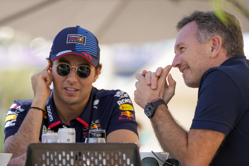 Red Bull team principal Christian Horner, right, chats with Red Bull driver Sergio Perez of Mexico at the pits during Formula One pre season test at the Bahrain International Circuit in Sakhir, Bahrain, Wednesday, Feb. 21, 2024. (AP Photo/Darko Bandic)